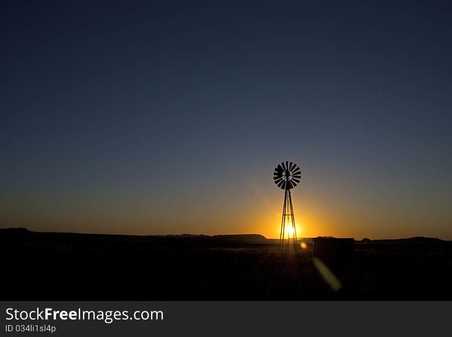 Windmill at sunset in clearing. Windmill at sunset in clearing