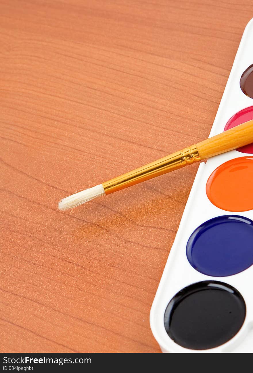 Paint brush and painters palette on wood background. Paint brush and painters palette on wood background