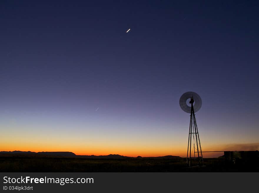 Windmill at sunset in clearing. Windmill at sunset in clearing