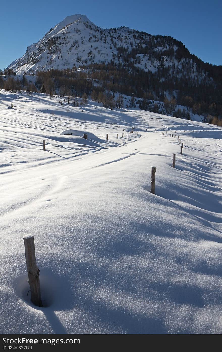 Road to Mortirolo Pass during winter. 1900 meters on the sea-level. Tarmac is under deep snow. Brixia province, Lombardy region, Italy. Road to Mortirolo Pass during winter. 1900 meters on the sea-level. Tarmac is under deep snow. Brixia province, Lombardy region, Italy