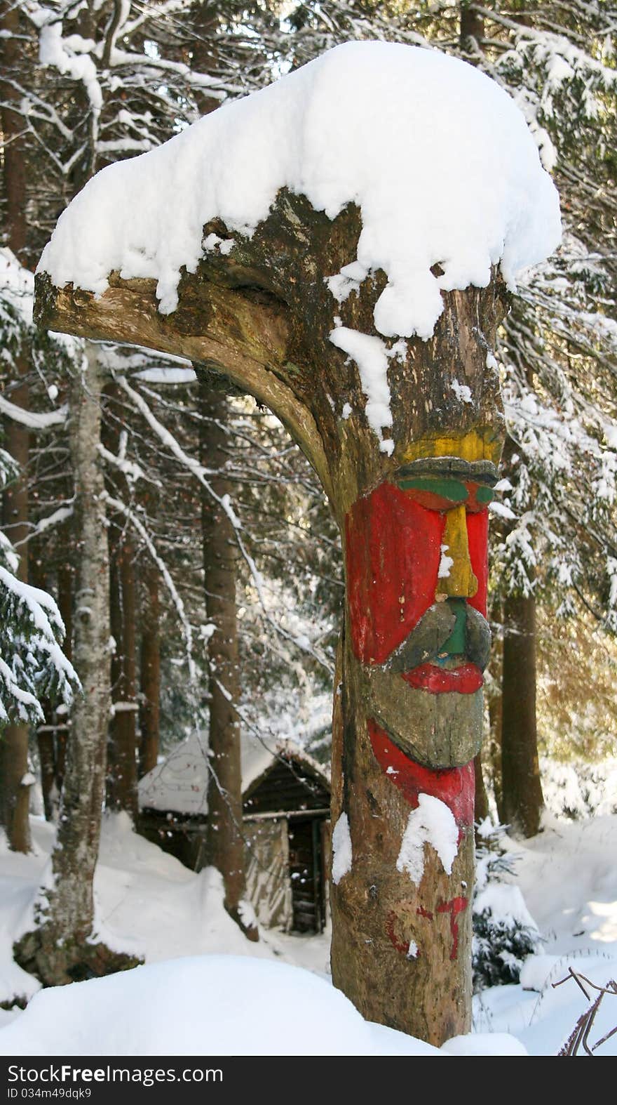 Handmade carved coloured totem in snow.