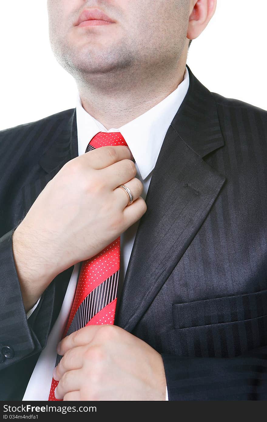 The businessman in a black suit corrects hands a tie. The businessman in a black suit corrects hands a tie