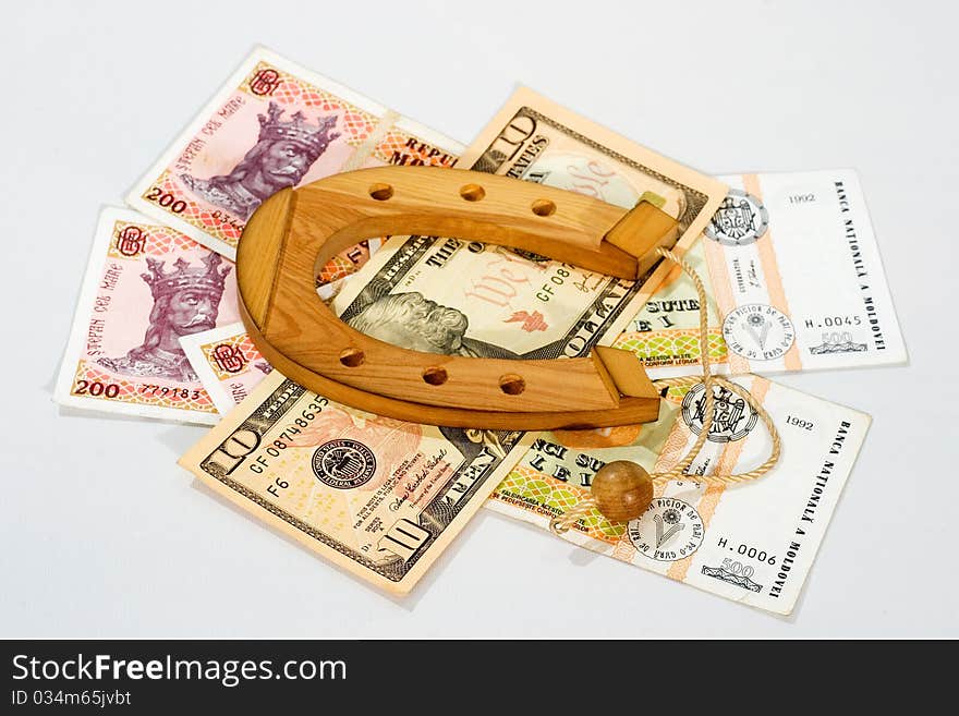 Wooden souvenir horseshoe is on the banknotes superstition luck omen. Wooden souvenir horseshoe is on the banknotes superstition luck omen