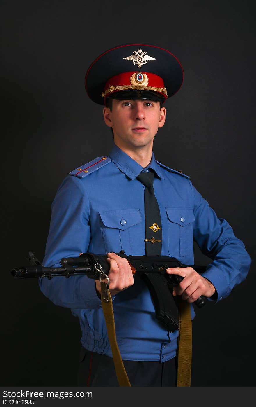 Police officer in uniform with machine gun AK-47