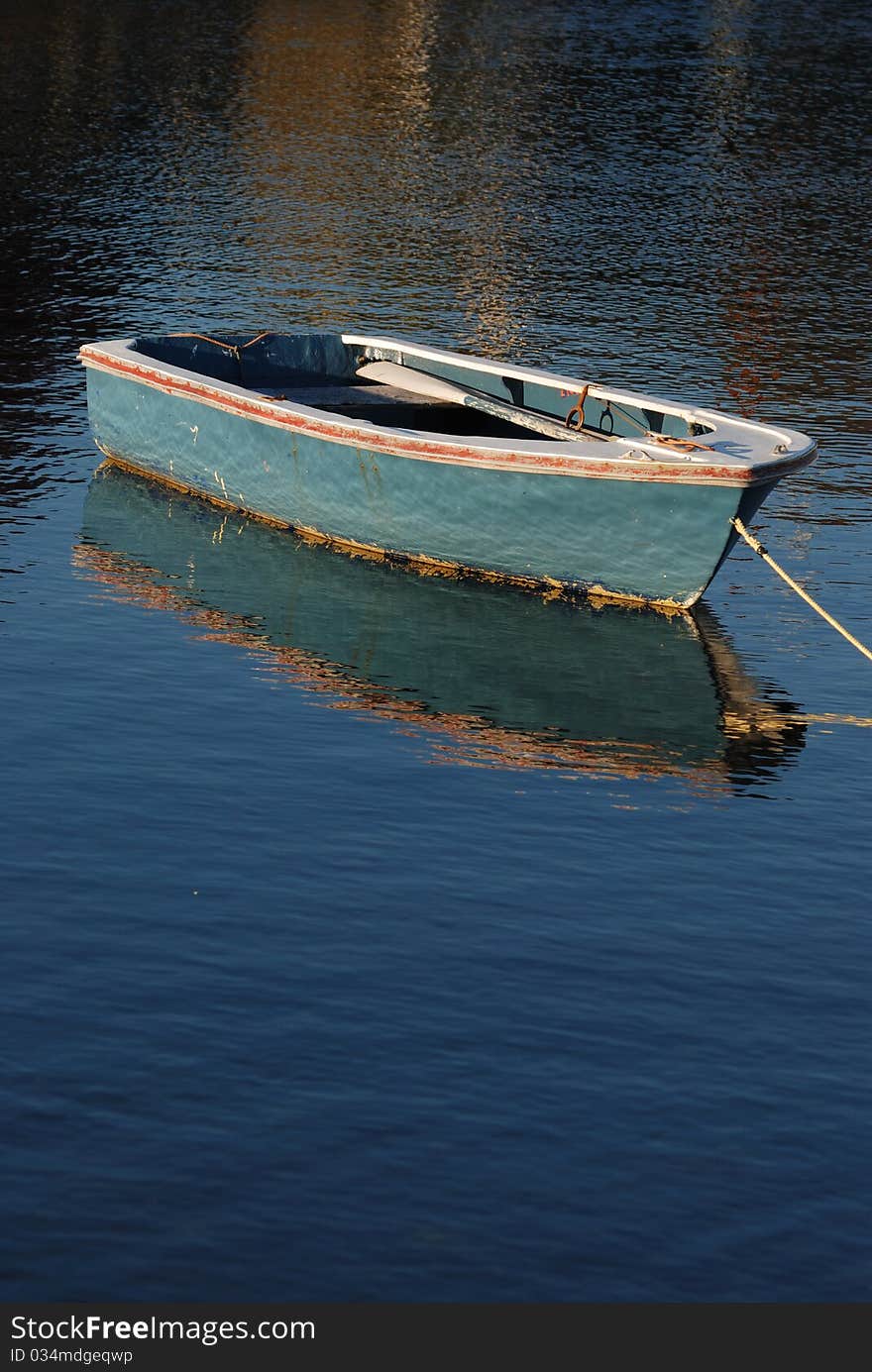 A rowboat sits empty on the water.