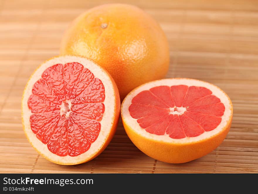 Two red juicy grapefruits on wooden carpet. Two red juicy grapefruits on wooden carpet