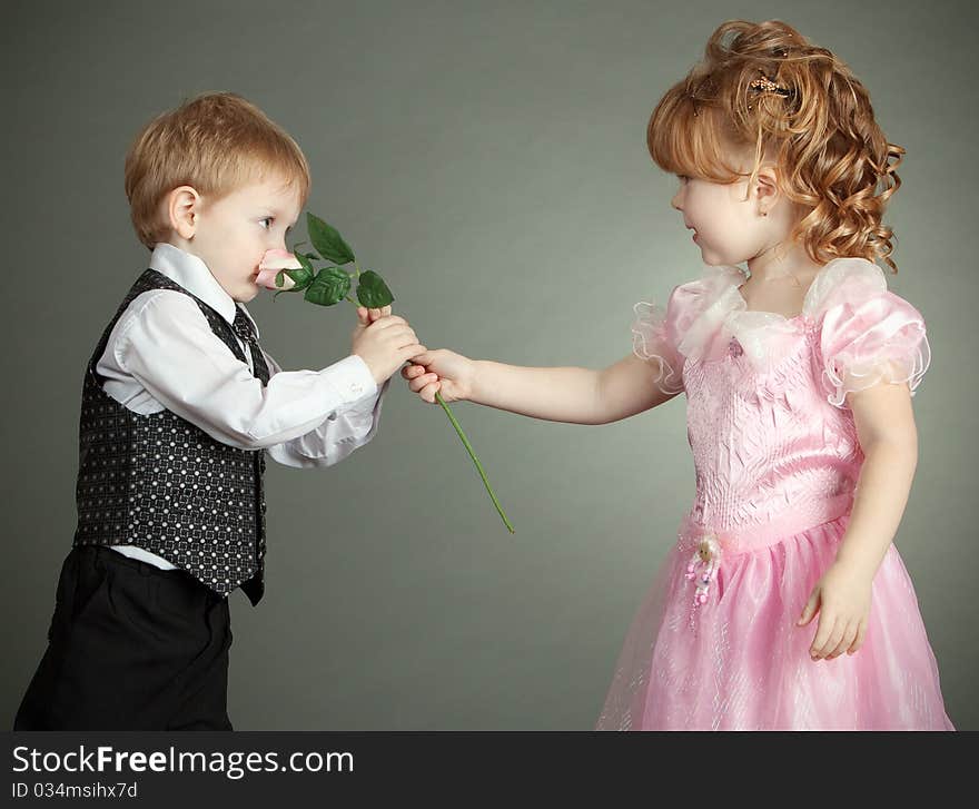 The little boy gives to the girl a flower. The little boy gives to the girl a flower