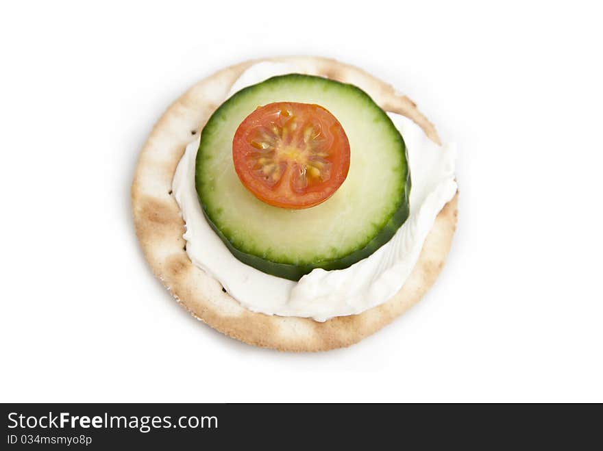 Cream cheese on a cracker with tomato and cucumber. Cream cheese on a cracker with tomato and cucumber