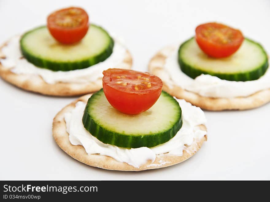 Cream cheese on a crackers with tomato and cucumber. Cream cheese on a crackers with tomato and cucumber