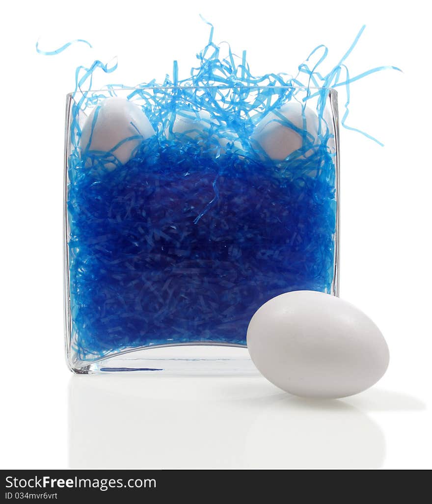 Glass vase becomes an easter basket with blue straw and undecorated eggs. Glass vase becomes an easter basket with blue straw and undecorated eggs