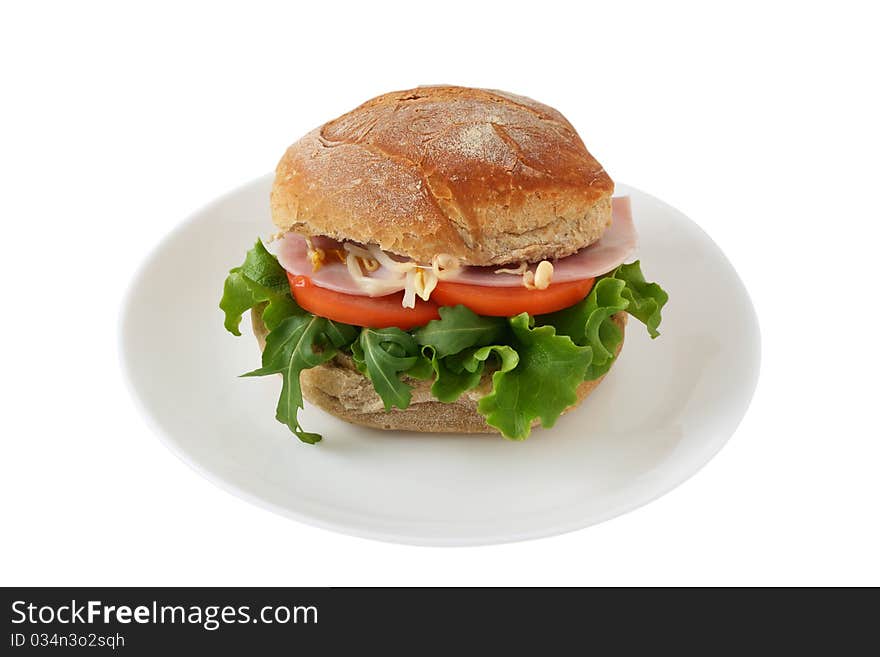 Sandwich with ham, salad and tomato on a plate