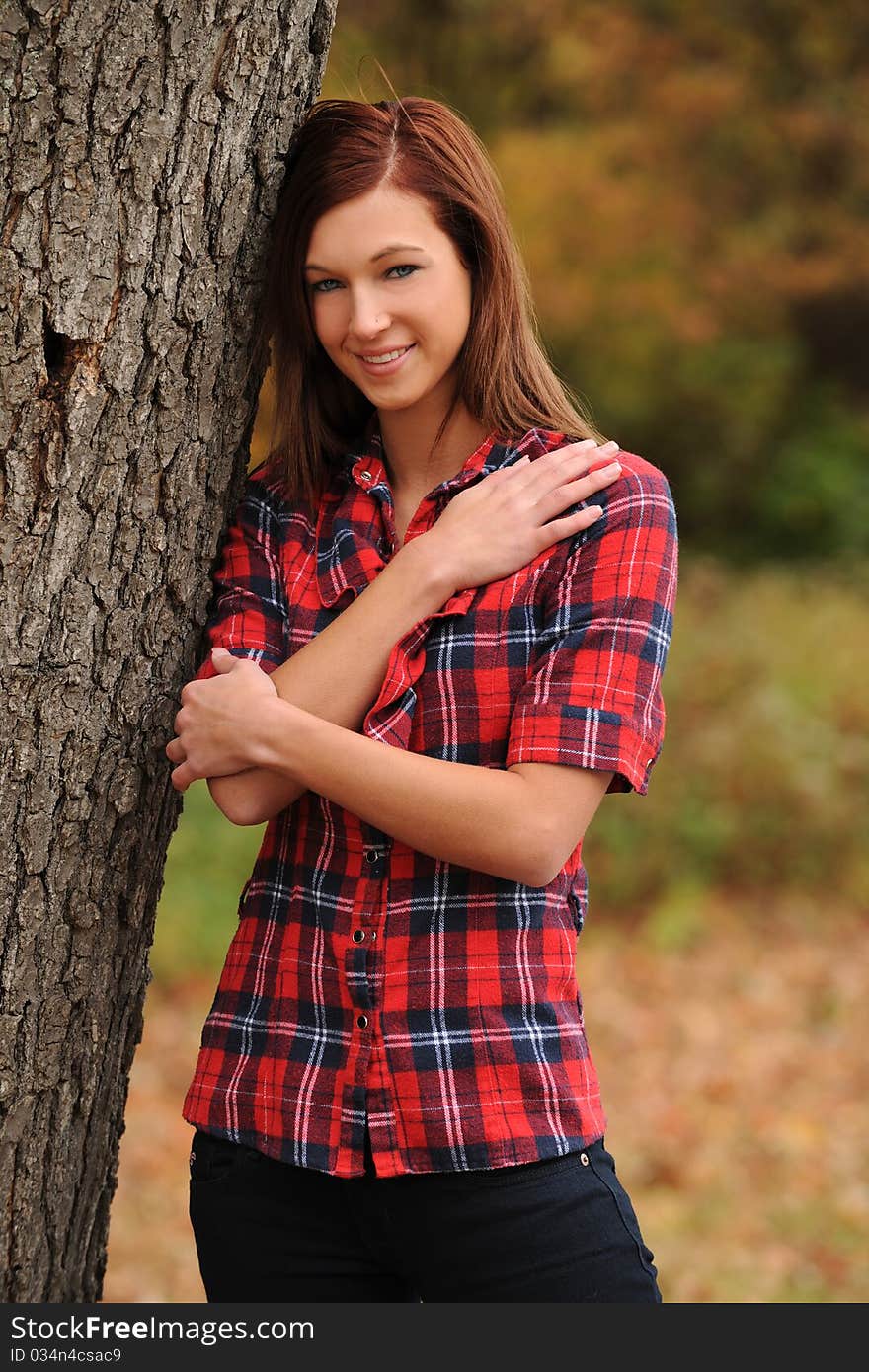 Young Woman Standing By A Tree