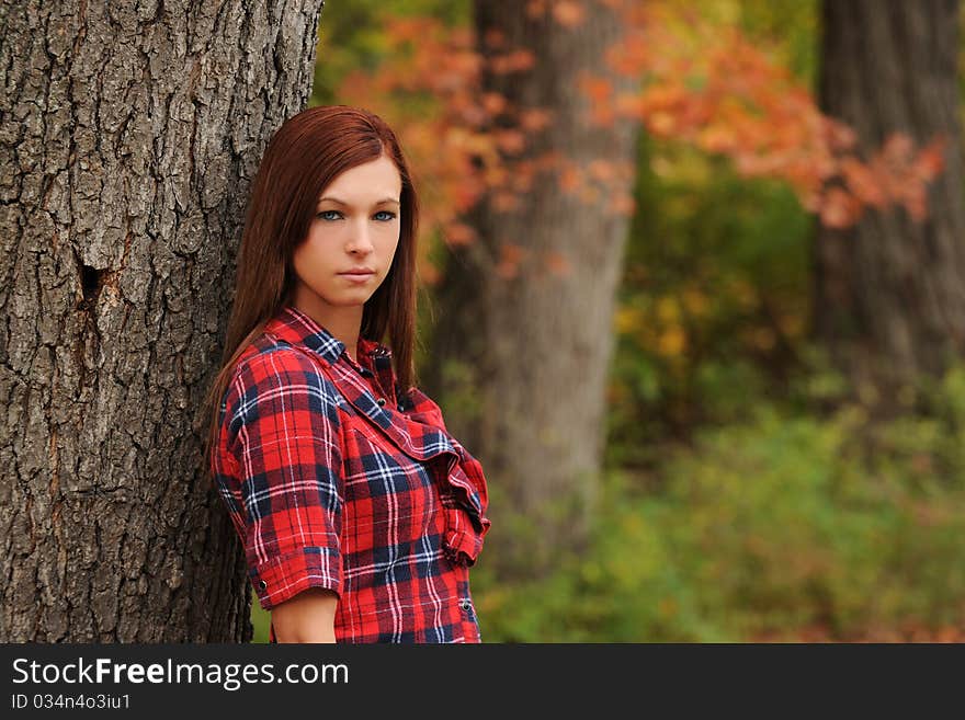 Young Woman Standing By A Tree