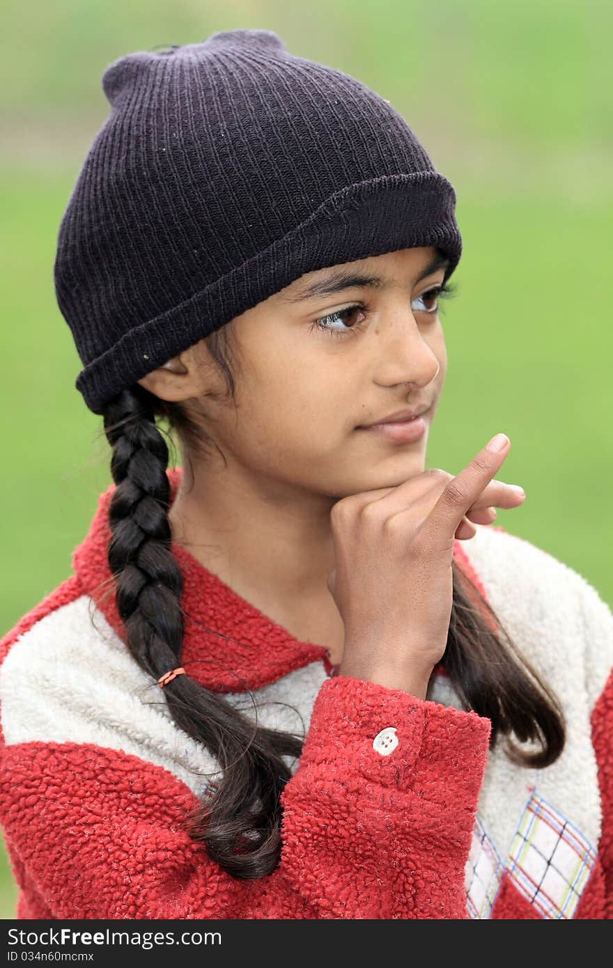 Portrait shot of cute indian girl with green background.