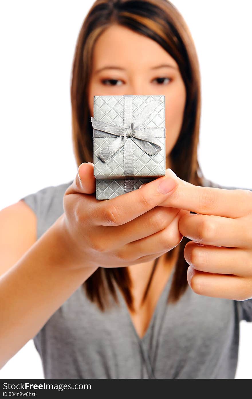 Attractive young woman opens a present, selective focus on giftbow. Attractive young woman opens a present, selective focus on giftbow