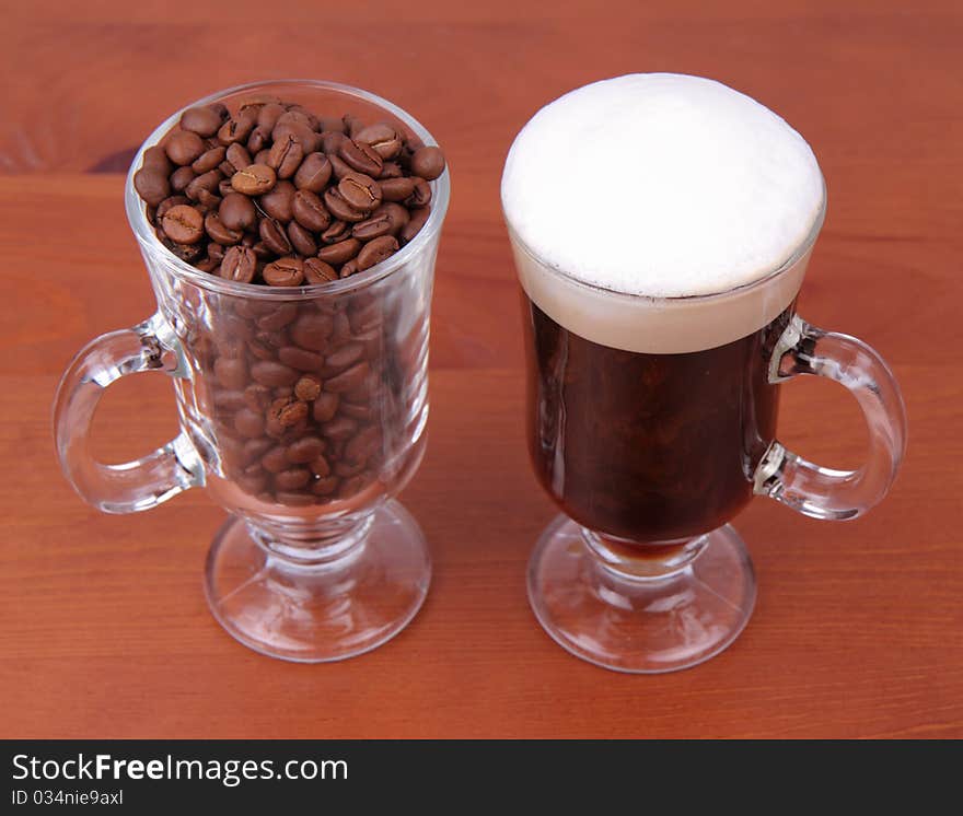 Glass of caffe latte with a glass of coffee beans on white background. Glass of caffe latte with a glass of coffee beans on white background