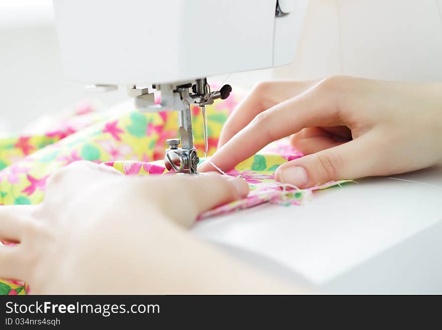 Fabric in a sewing machine on a light background