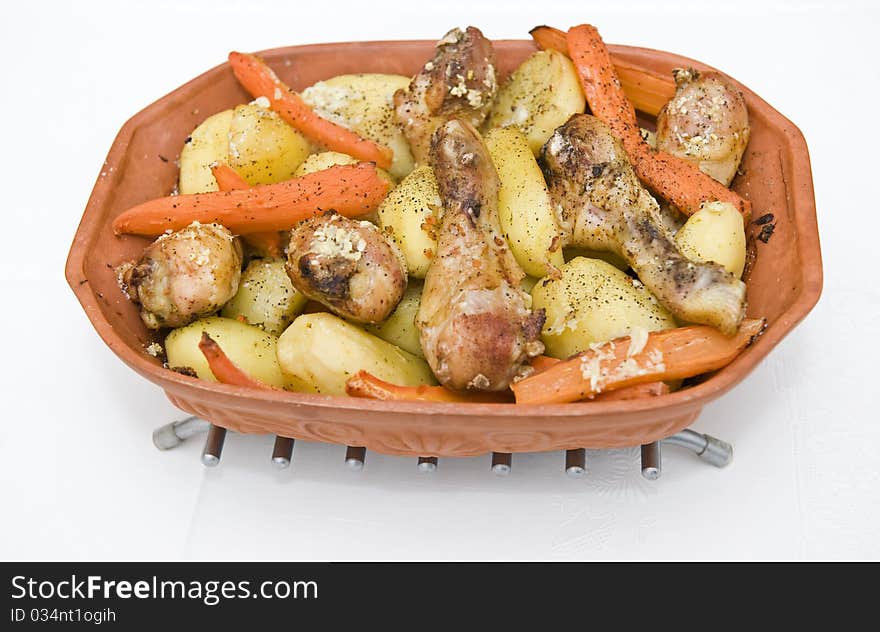 Roasted chicken and potatoes on a pot