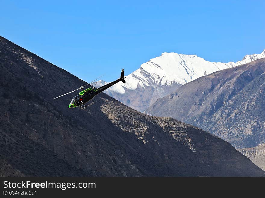 Black helicopter over Annapurna range