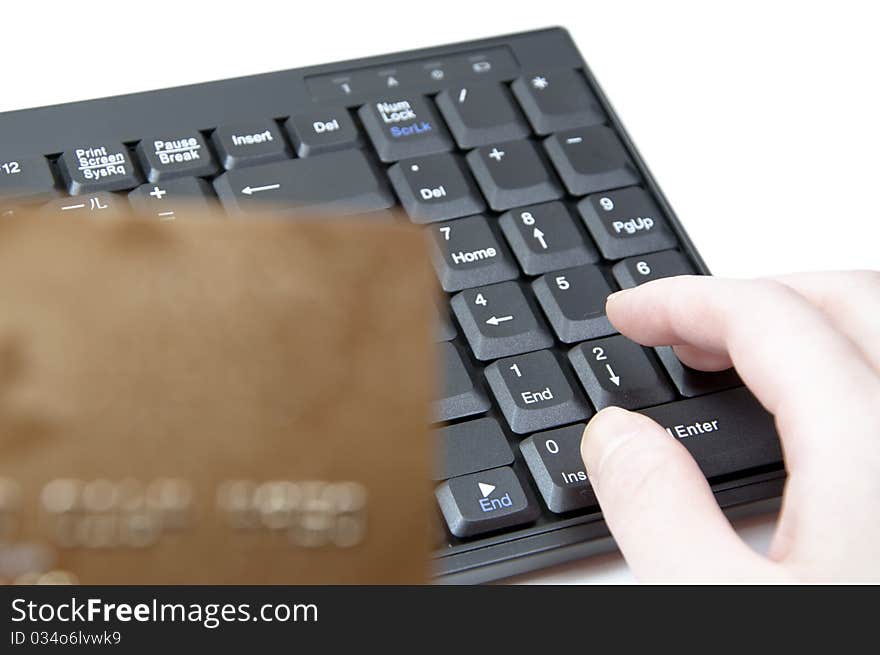 HANDS HOLDING CREDIT CARD WITH KEYBOARD