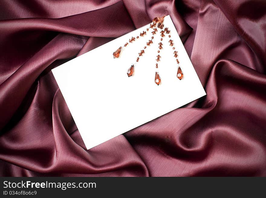 Empty greeting card on ruby satin background. Empty greeting card on ruby satin background