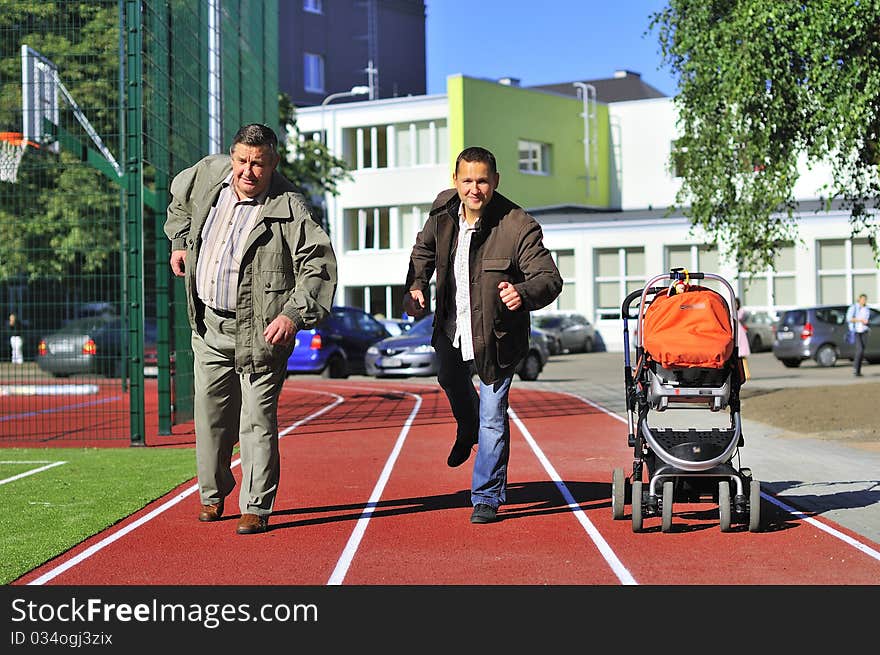 Father, son and grandson running on the running track. Father, son and grandson running on the running track.