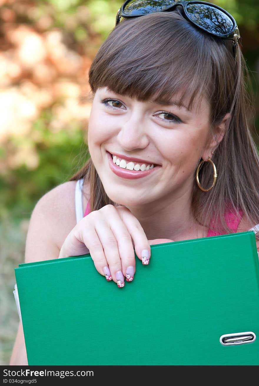 Young beautiful student with the unfolded folder. Young beautiful student with the unfolded folder.