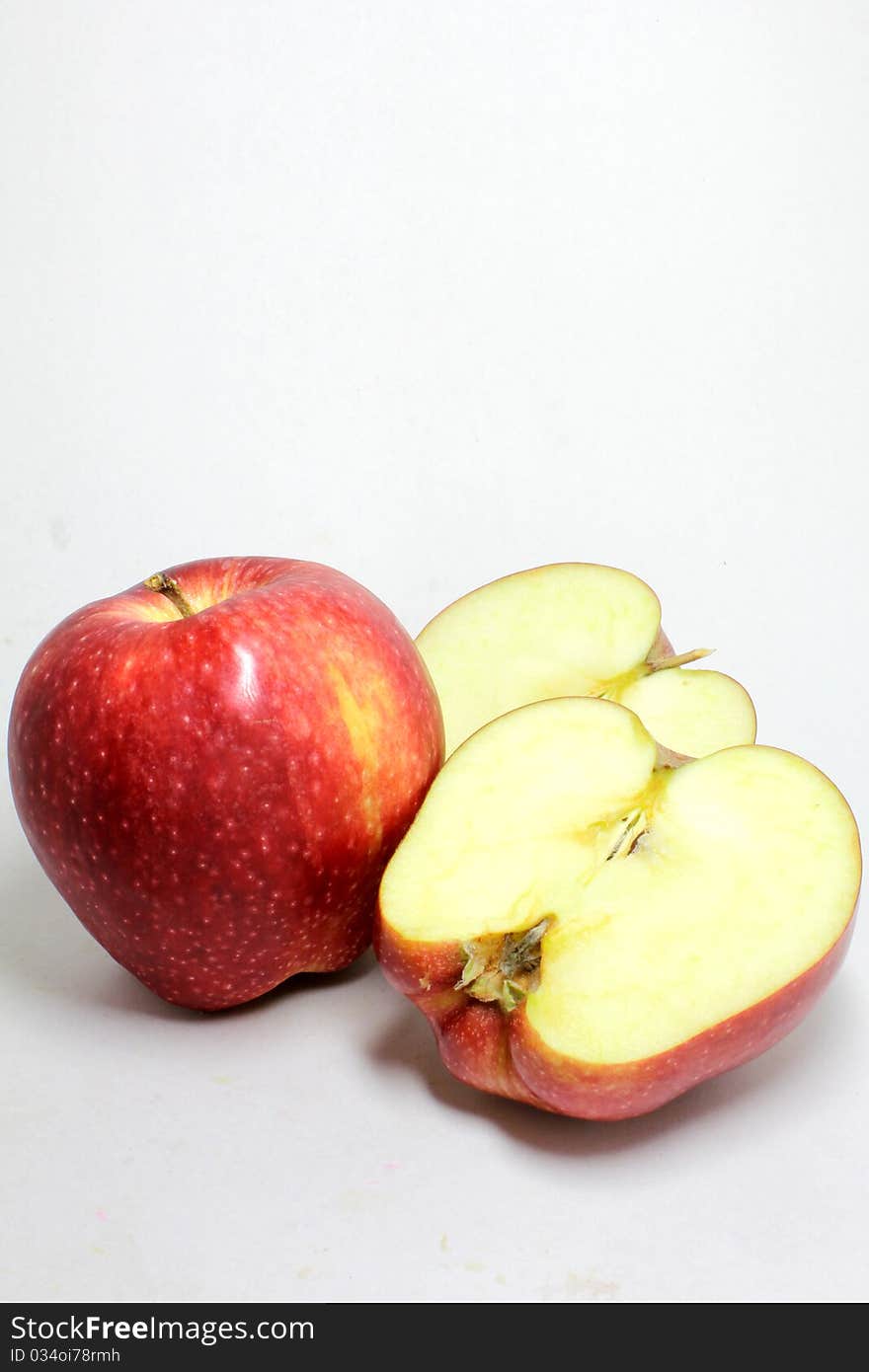 Red apple and its half isolated on white