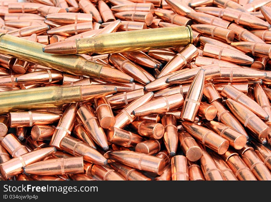 Pile of loose bullets with two loaded cartridges laying on top. Pile of loose bullets with two loaded cartridges laying on top.