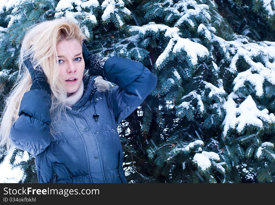 Young Blonde Standing Near The Snowed Spruce