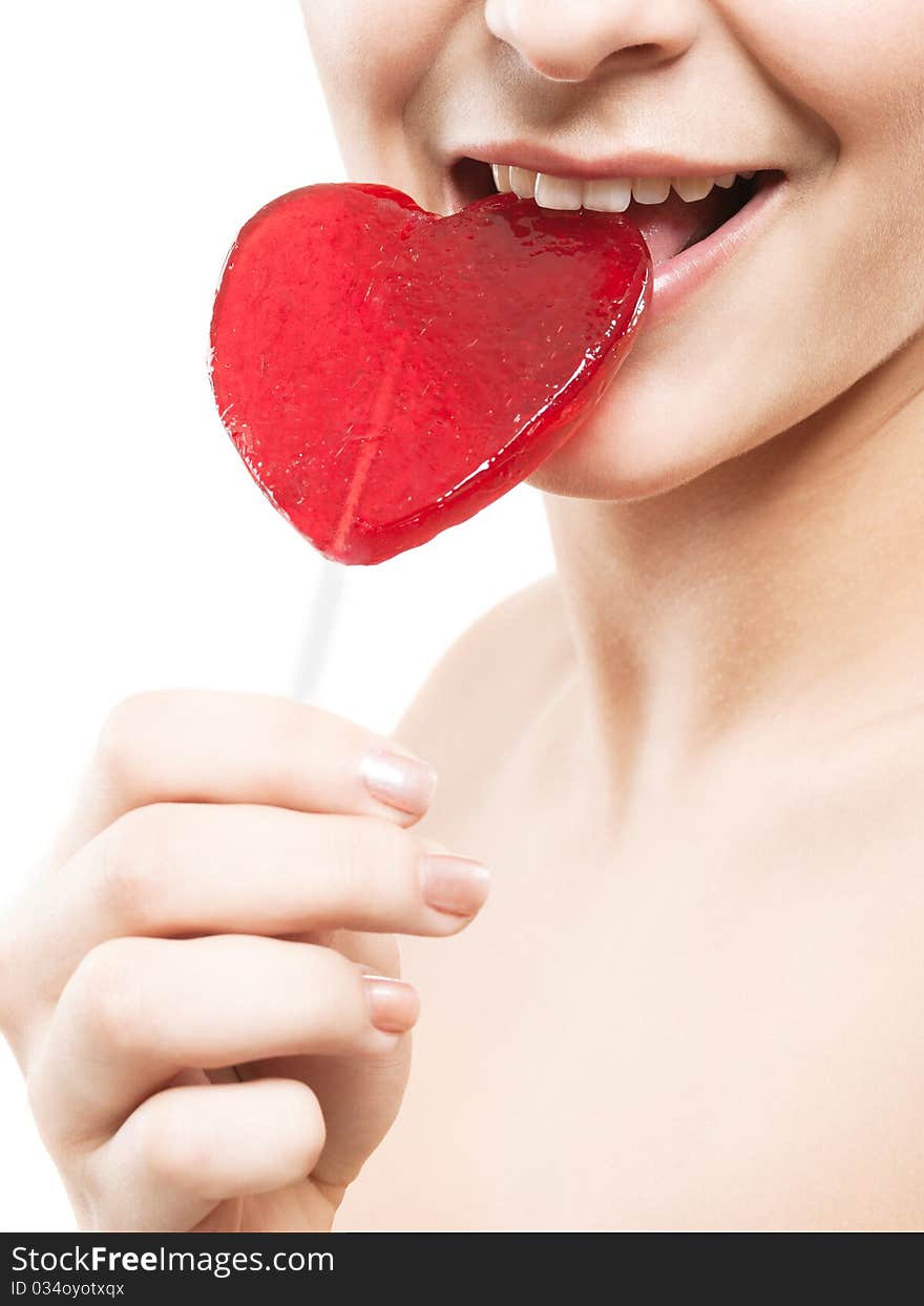 Closeup shot of girl with red heart lolipop isolated on white