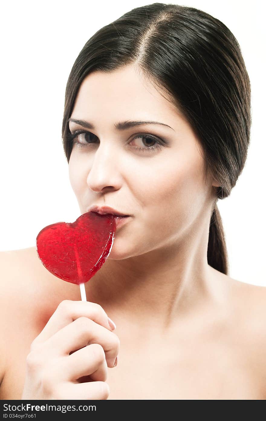 Closeup shot of girl with red heart lolipop isolated on white