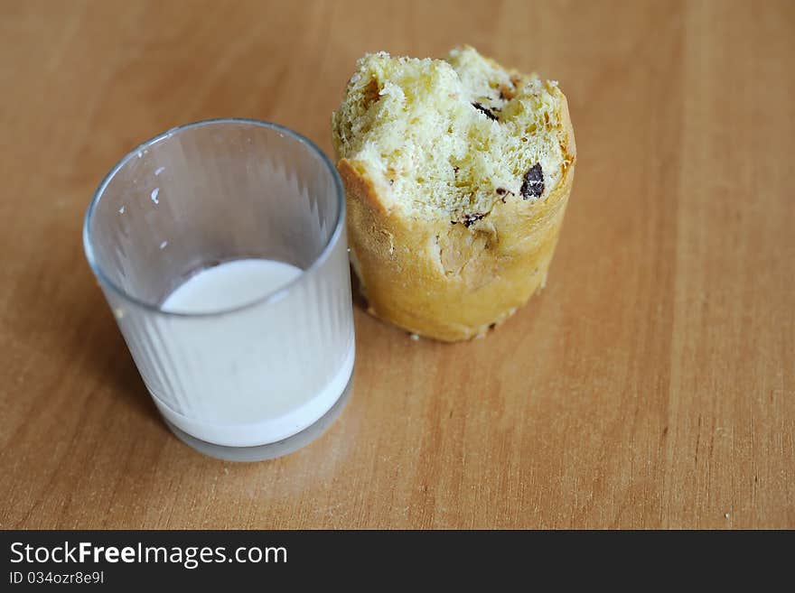 An image of a cake and a glass with some milk on a table. An image of a cake and a glass with some milk on a table