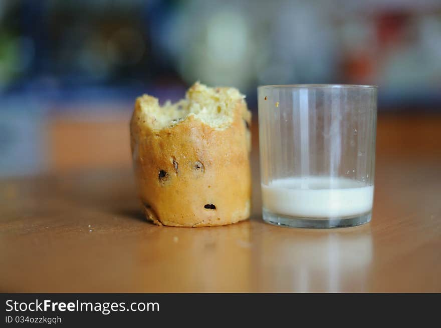 An image of a cake and a glass with some milk on a table. An image of a cake and a glass with some milk on a table