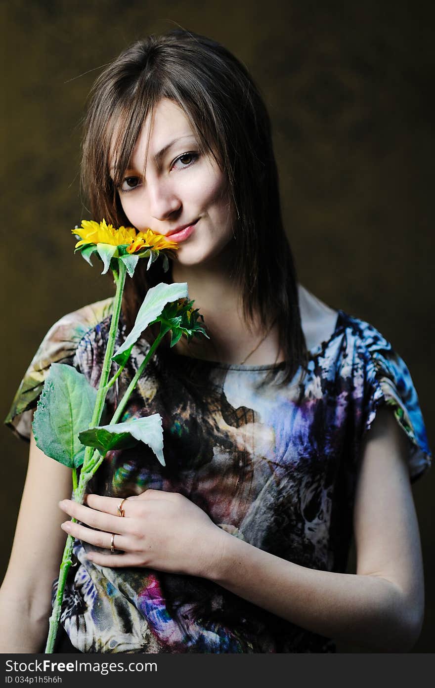 A beautiful woman with a sunflower in her hand. A beautiful woman with a sunflower in her hand