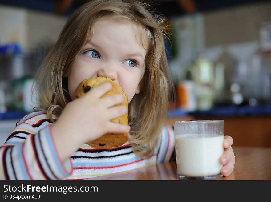 An image of a girl eating cookie with milk. An image of a girl eating cookie with milk