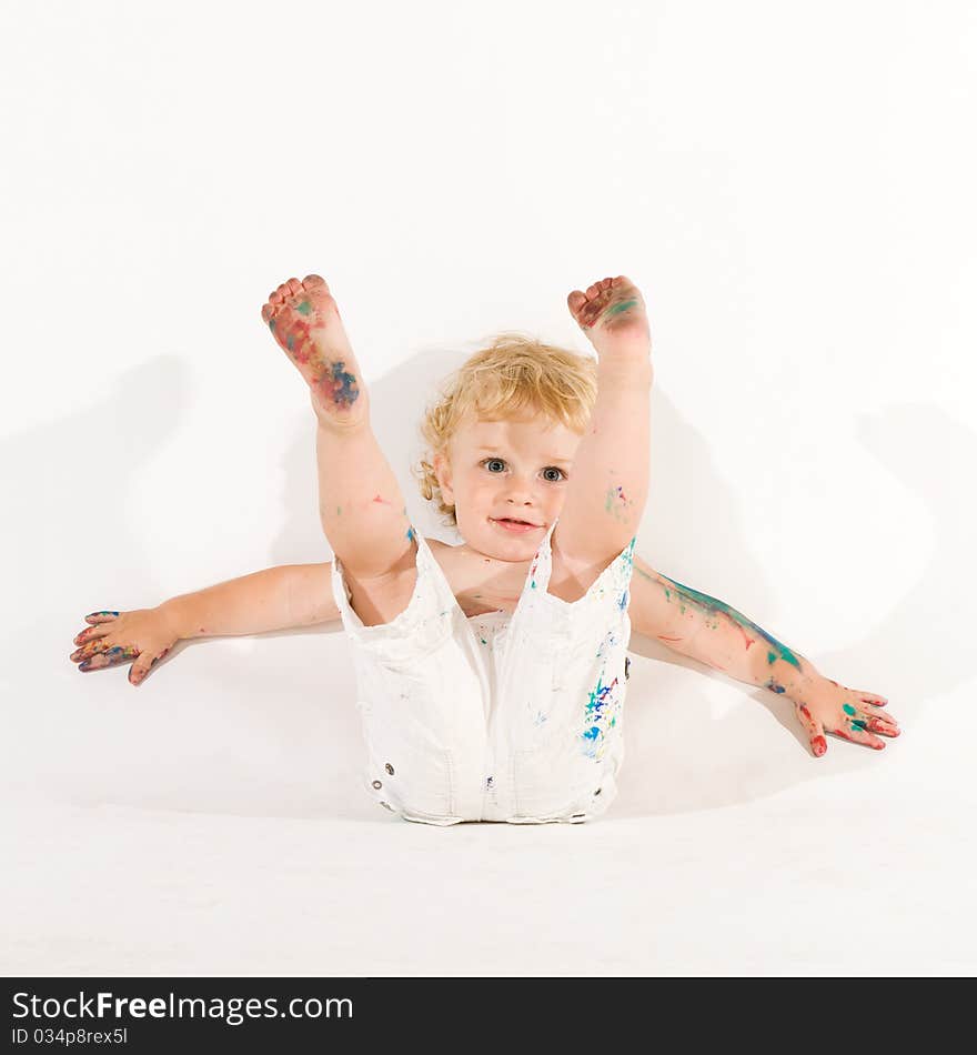 Beautiful playful little child playing with colors isolated on white background. Beautiful playful little child playing with colors isolated on white background