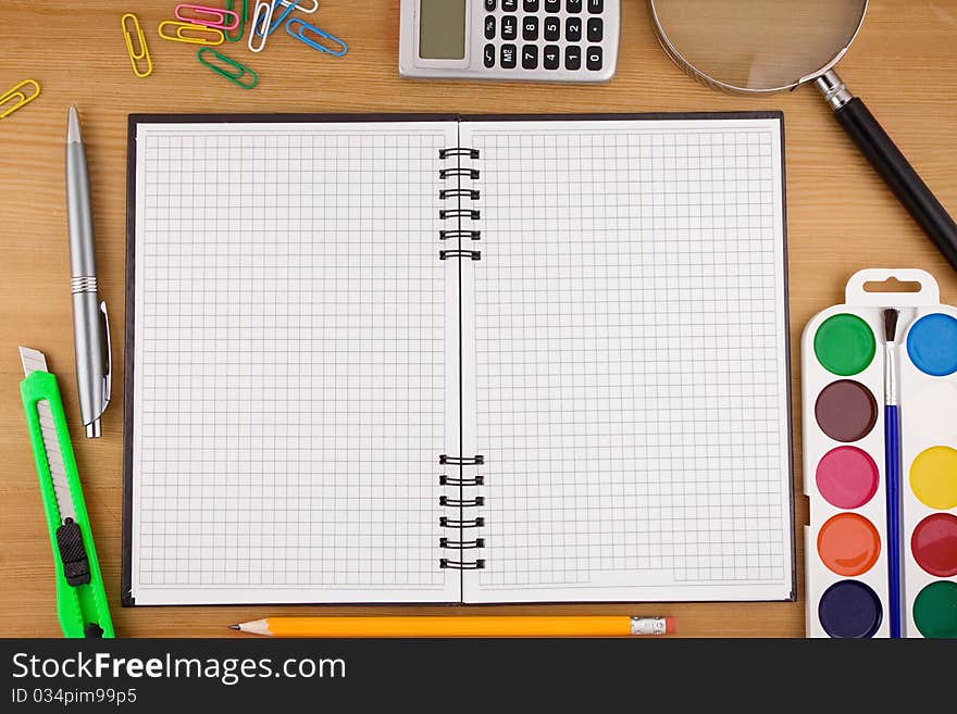 School accessories and checked notebook on wood texture