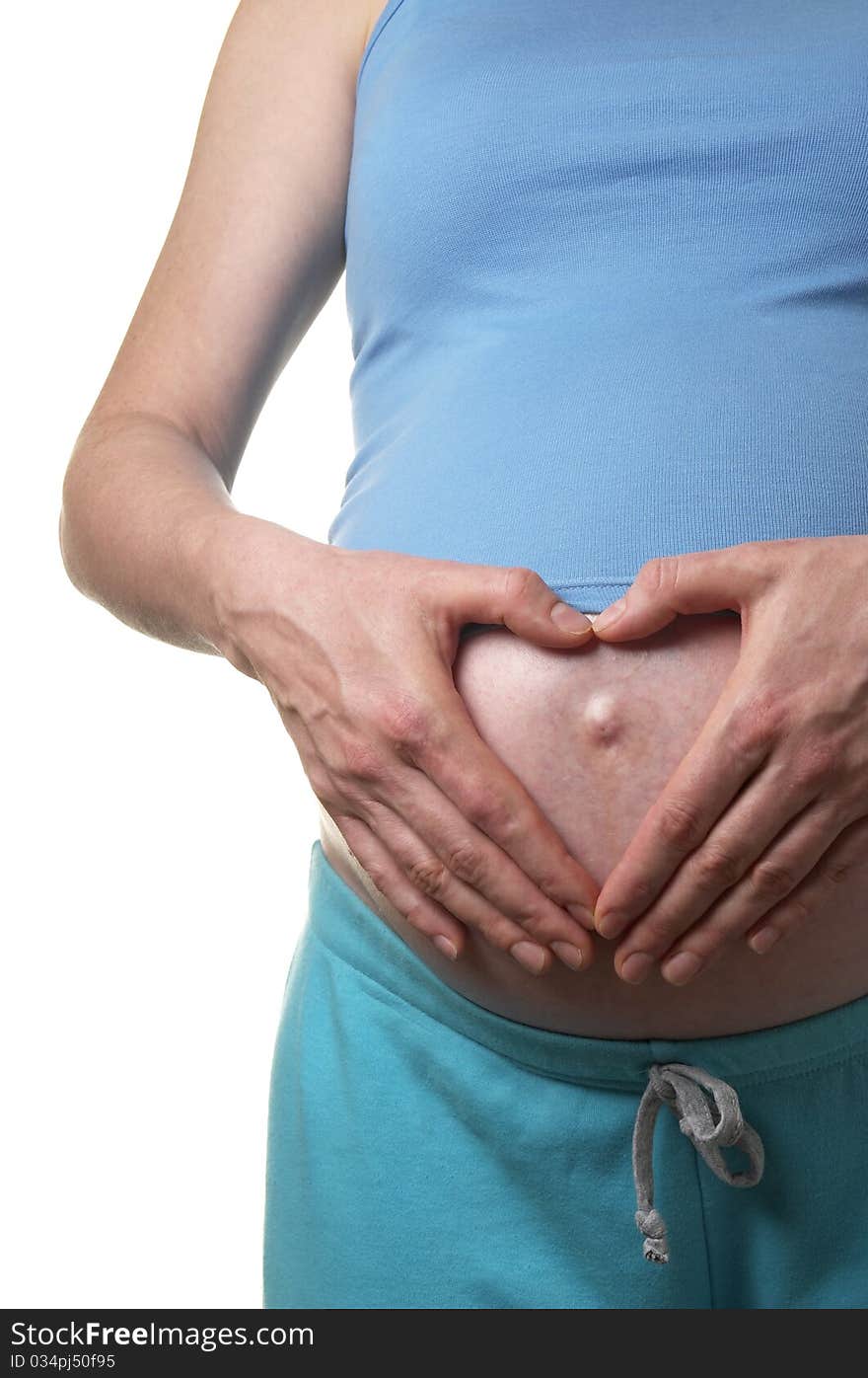 Pregnant woman profile with heart shape hands on the stomach over white background. Pregnant woman profile with heart shape hands on the stomach over white background