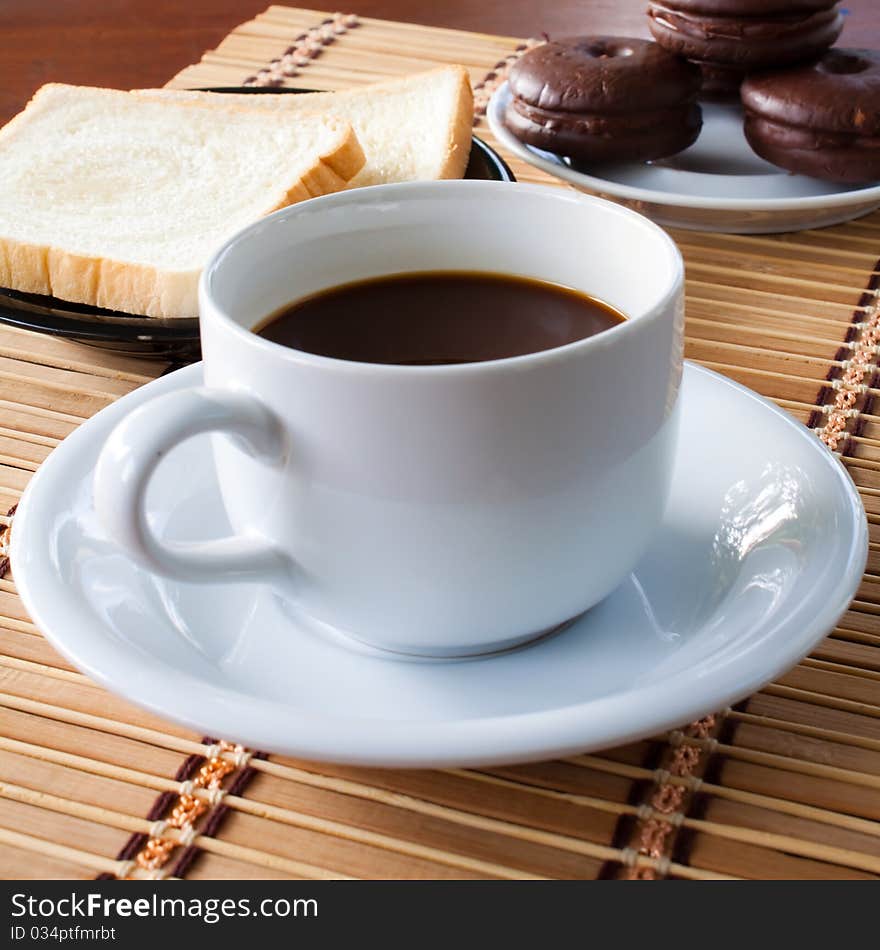 Cup of coffee and bread on table