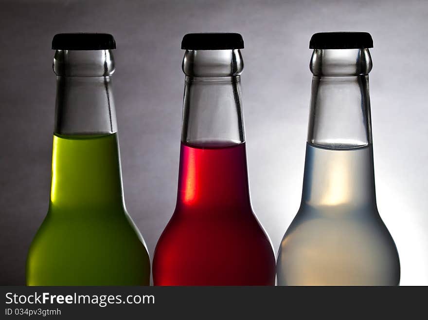 Three colorful bottle of drink on light background