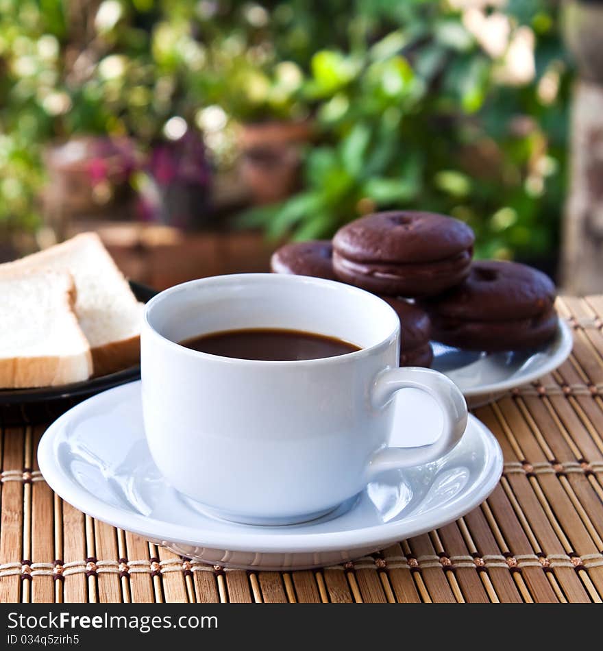 Cup of coffee and bread on table