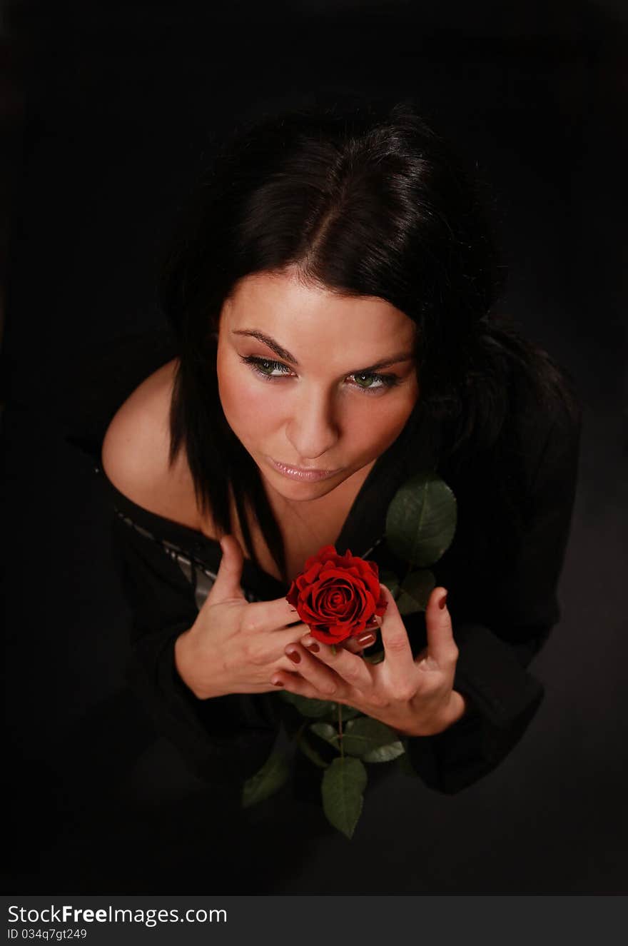 Beautiful girl with red rose standing in the dark. Beautiful girl with red rose standing in the dark