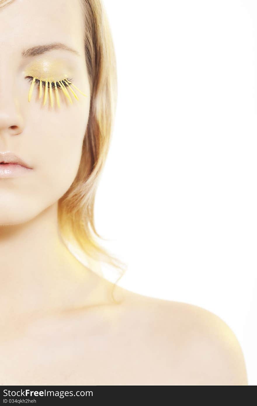 Beautiful young woman wearing yellow petal eyelashes. Beautiful young woman wearing yellow petal eyelashes