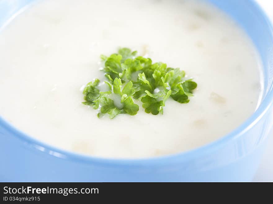 Blue bowl of onion pureed soup with parsley