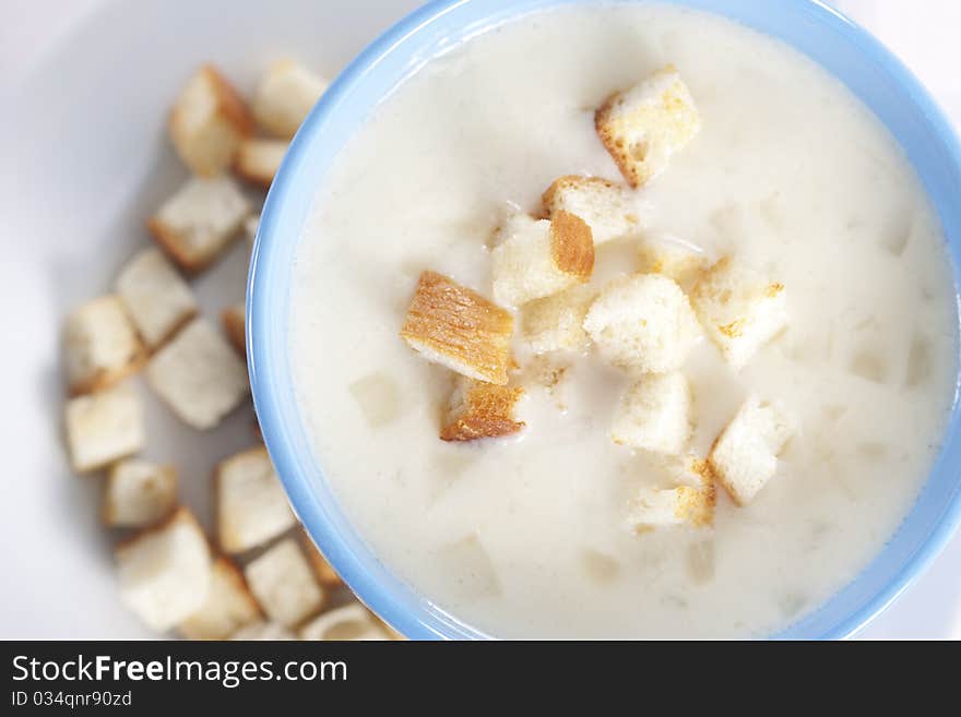 Two blue bowls of onion pureed soup with croutons