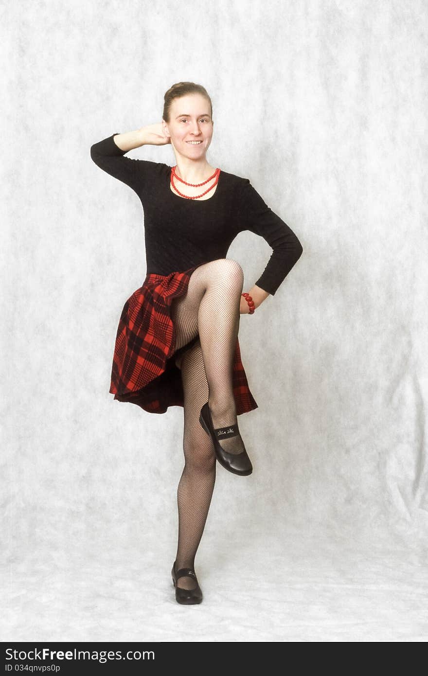 Girl dancing cancan in red scottish skirt