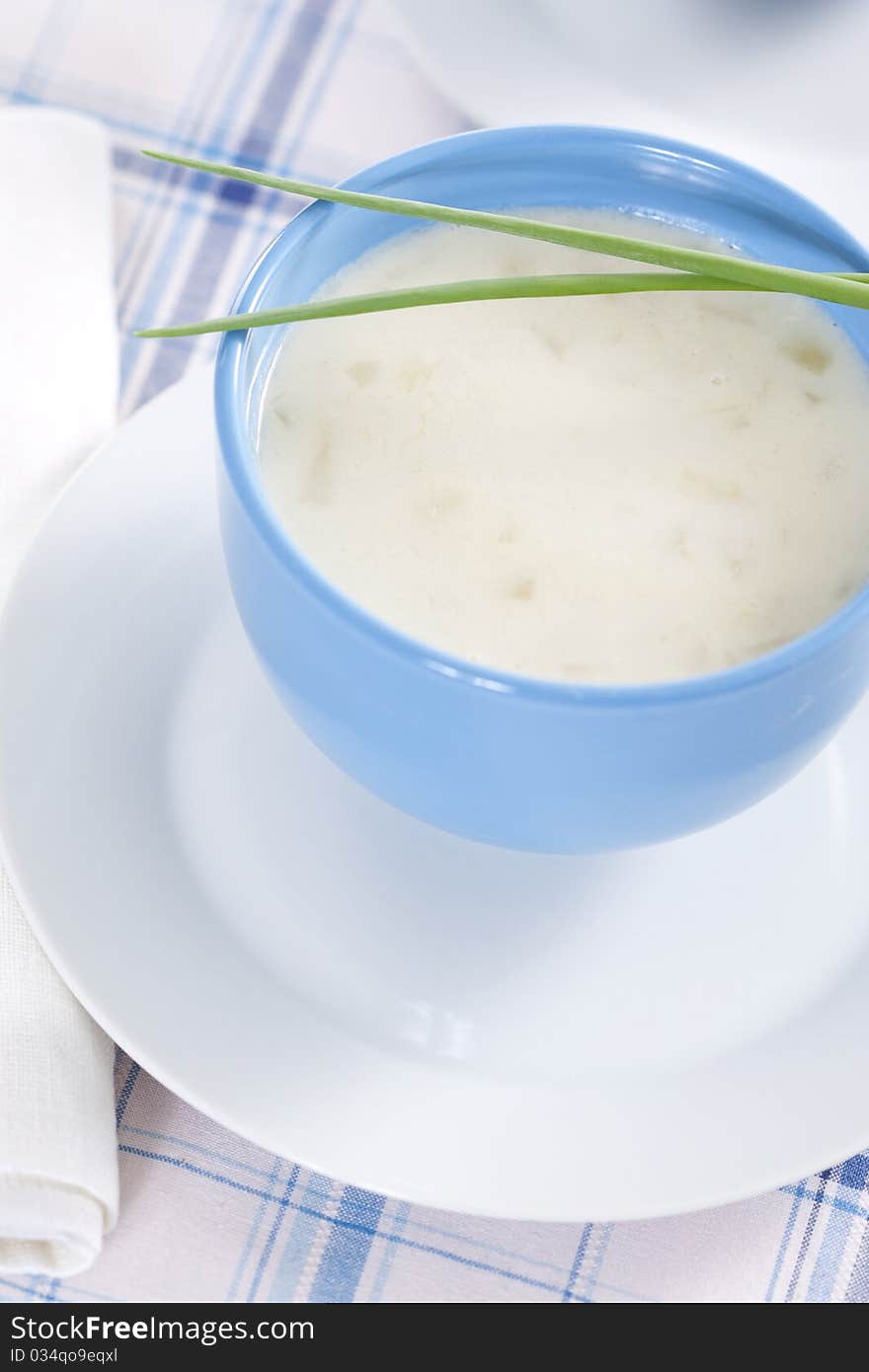 Two blue bowls of onion pureed soup with leek