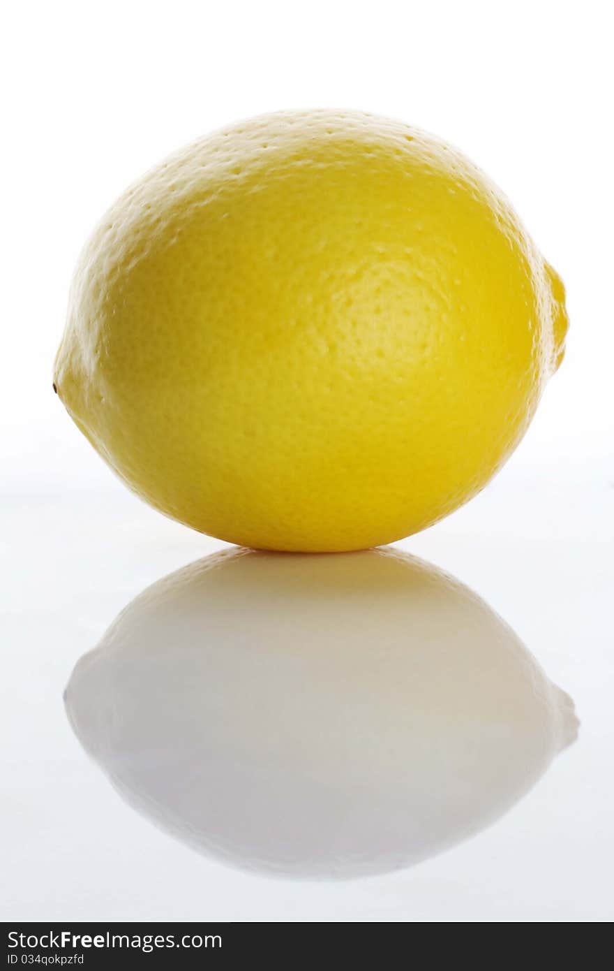 Single lemon with reflection on white