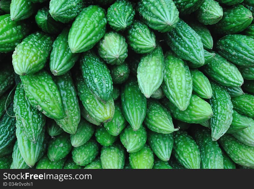 Green small bitter gourd stack up nicely in market.